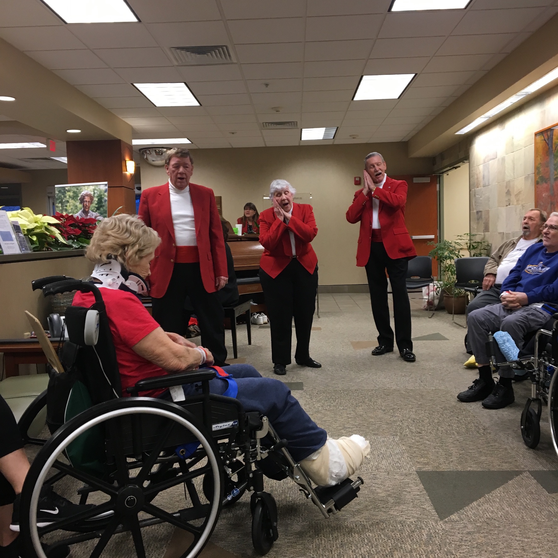 Resident in a wheelchair being applauded at a senior living community event