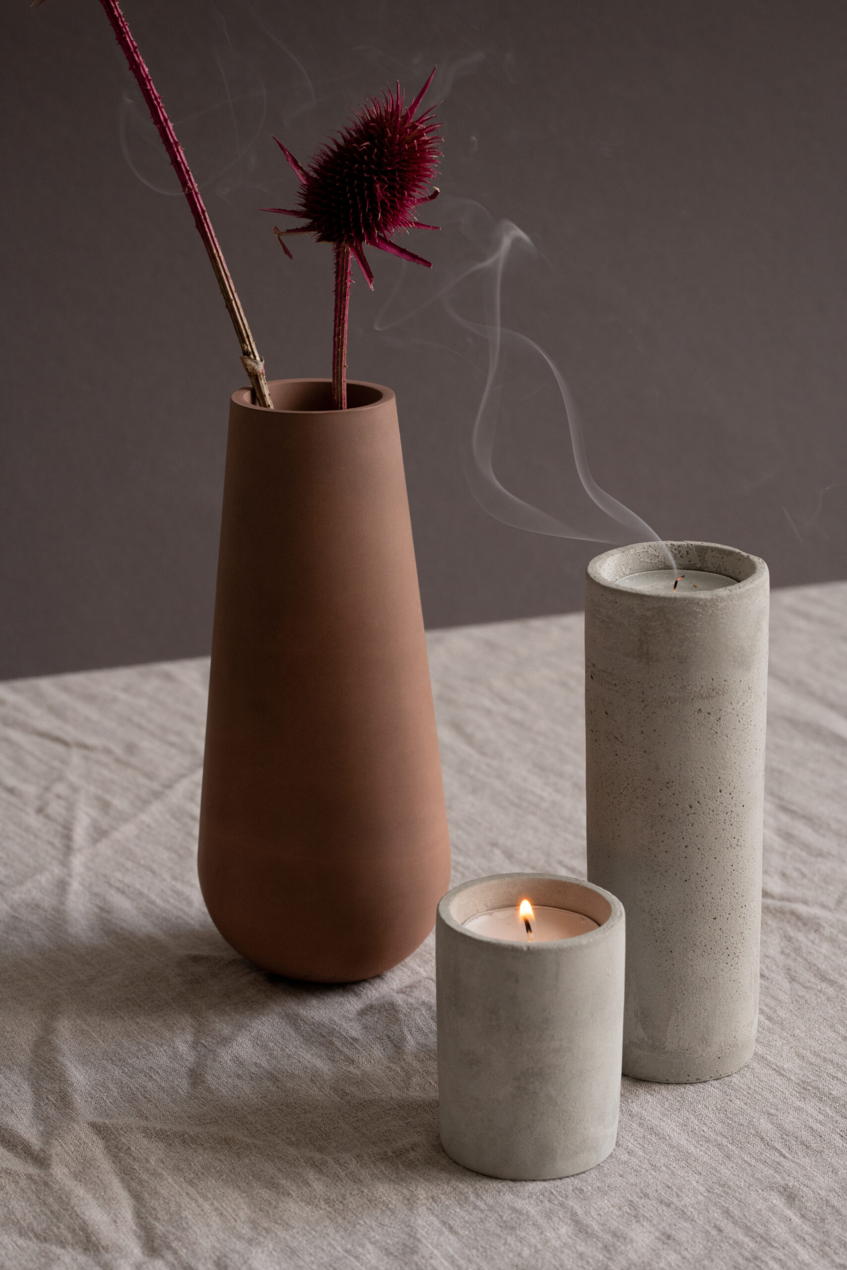 Two ceramic vessels with incense smoke against a dark background, a calm bedside vignette