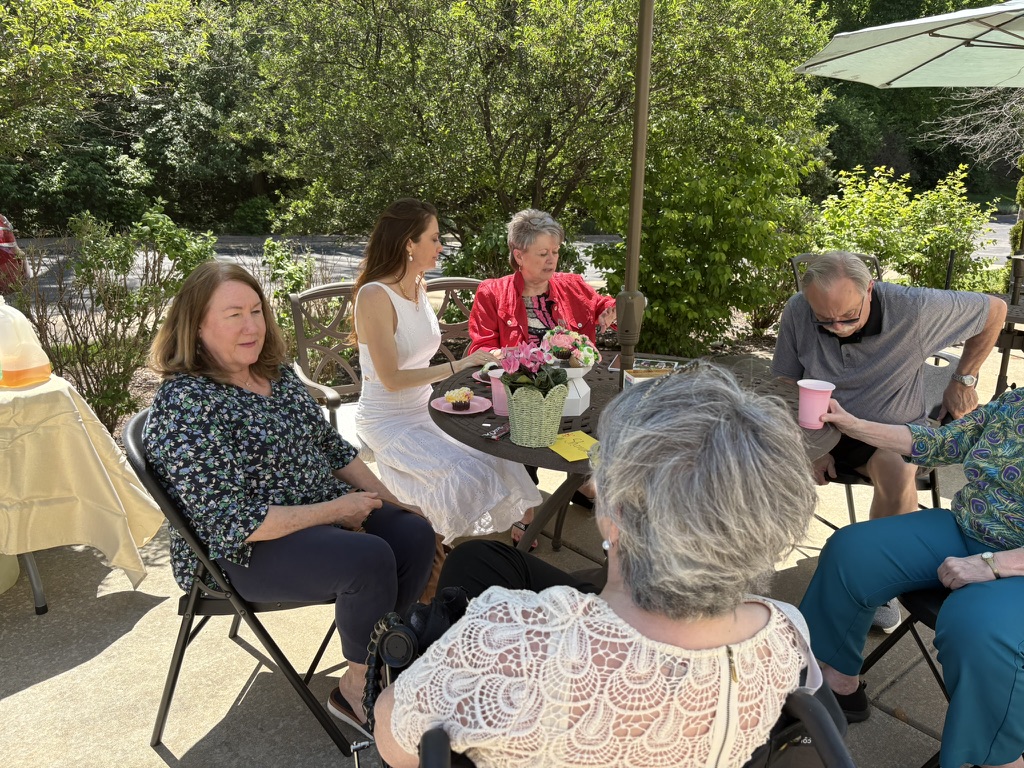 Multi-generational group of women talking around a garden table