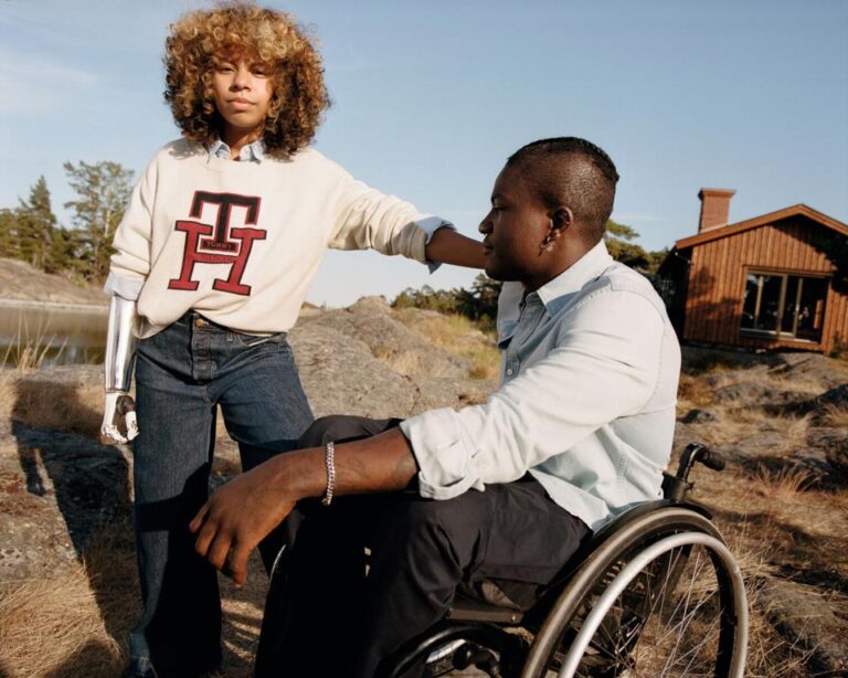 Two men outdoors, one wearing a prosthetic arm, in adaptive clothing