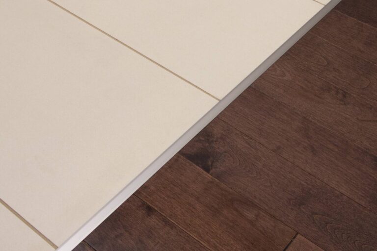 Flush floor transition between tile and dark wood with no raised threshold