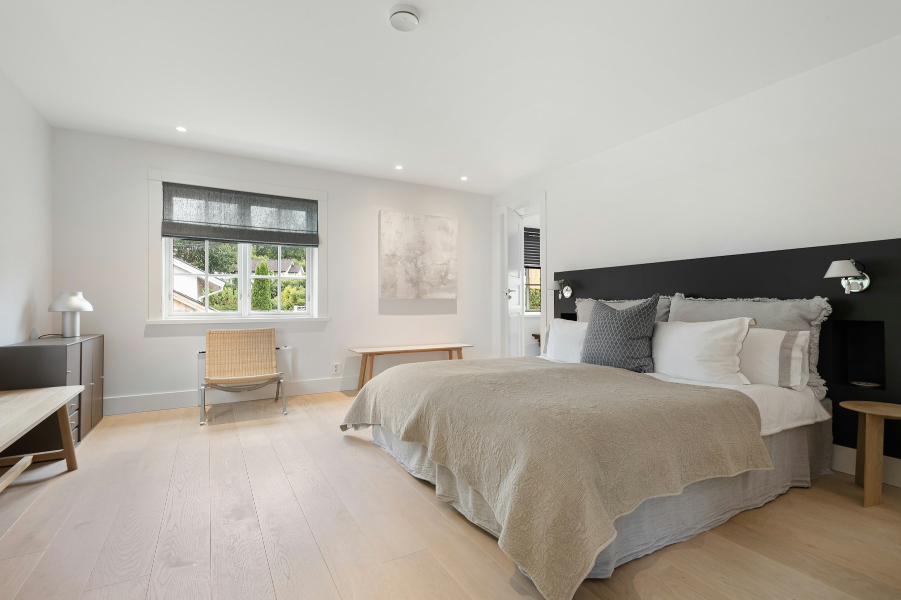 Calm guest suite bedroom with wide oak floors and open floor space around the bed